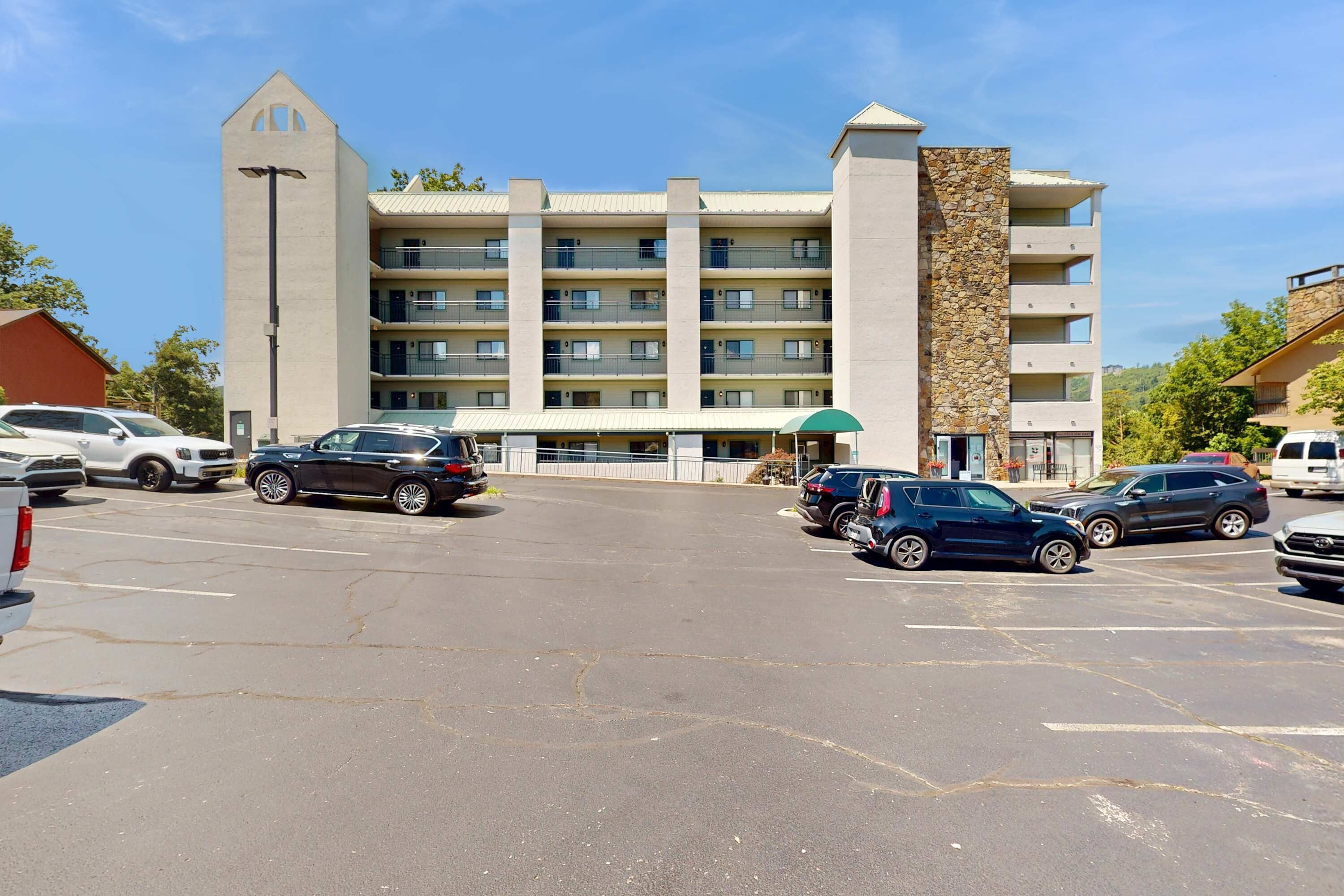 Un hôtel à plusieurs étages doté d’une cour intérieure, d’un parking et d’une structure distinctive en forme de tour.