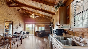 A wooden cabin interior with a dining area, kitchen, and seating space. - Secluded Smoky Mtn Cabin Escape・Views・Pet Friendly (Townsend)