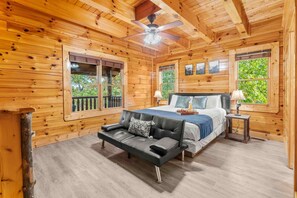 Ein Schlafzimmer einer Holzhütte mit einem Bett, einer Couch und einem kleinen Tisch.