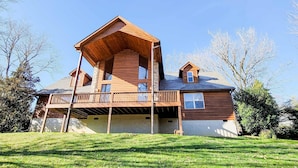 Una baita in legno a due piani con un balcone e un portico coperto.