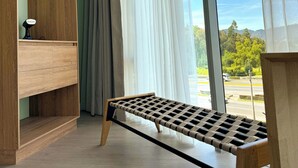 A room with a large window, a wooden bench, and a built-in shelf unit. - Hotel B3 Sibelius (Chía)