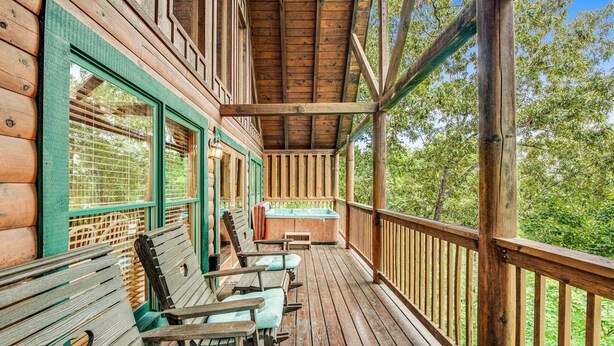 Une terrasse en bois avec quatre chaises en bois et un jacuzzi.