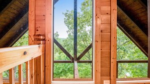Une chambre mansardée en bois avec une grande fenêtre.