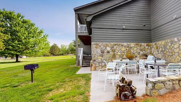 A building with a stone exterior and a covered patio area with outdoor seating.