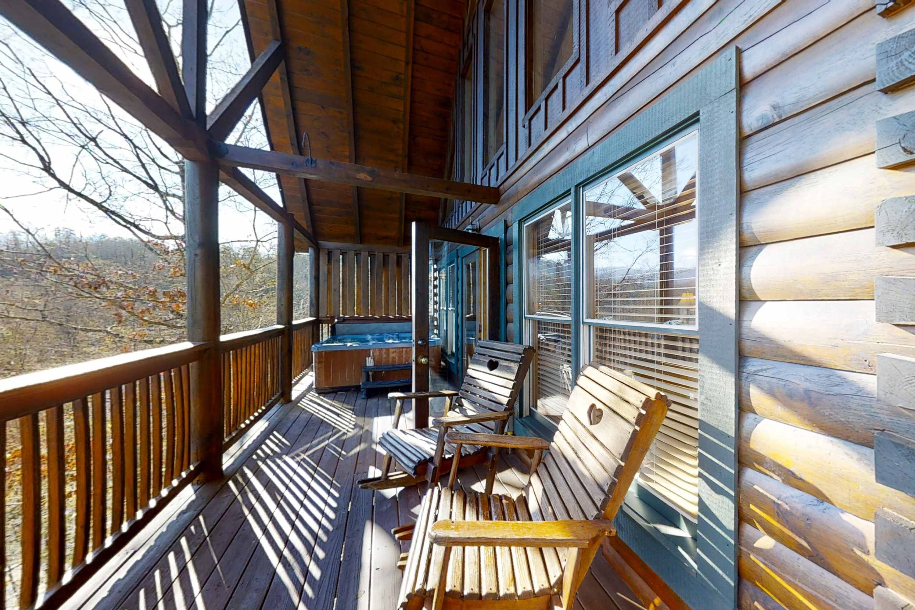 A wooden deck with a view of the surrounding landscape, a bench, and a small table.