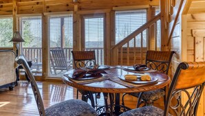 A wooden interior with a round table, chairs, and a staircase. - Family Friendly Luxe Mtn Getaway・Near Downtown (Pigeon Forge)