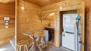 A wooden interior with a dining table, stools, a refrigerator, and a microwave. - Cabin W Amazing Views・Hot Tub・Shared Sauna - Pool (Pigeon Forge)