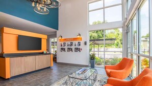 A modern interior with a large TV, a reception desk, and a wall with photos. - Landing | Stunning 1BD, Courtyard (Springfield)