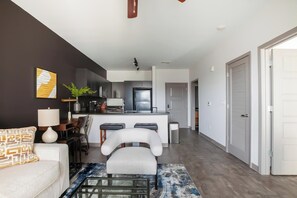 A modern apartment with a living room, kitchen, and dining area.