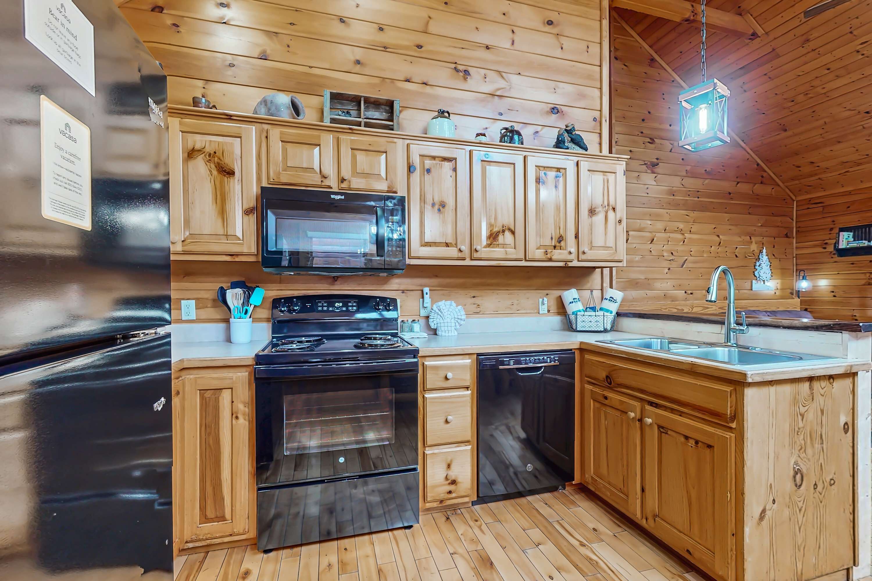 A kitchen with wooden cabinets, a stainless steel refrigerator, a microwave, an oven, and a dishwasher.
