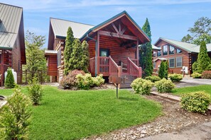 Ein Hotel im Chalet-Stil mit einem zentralen Gebäude, das eine Veranda und eine Treppe aufweist.