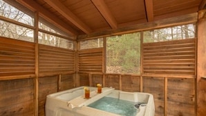 A wooden cabin with a large bathtub and a small window. - Cabin near Dolly - Parkway・Hot Tub・Screened Porch (Pigeon Forge)