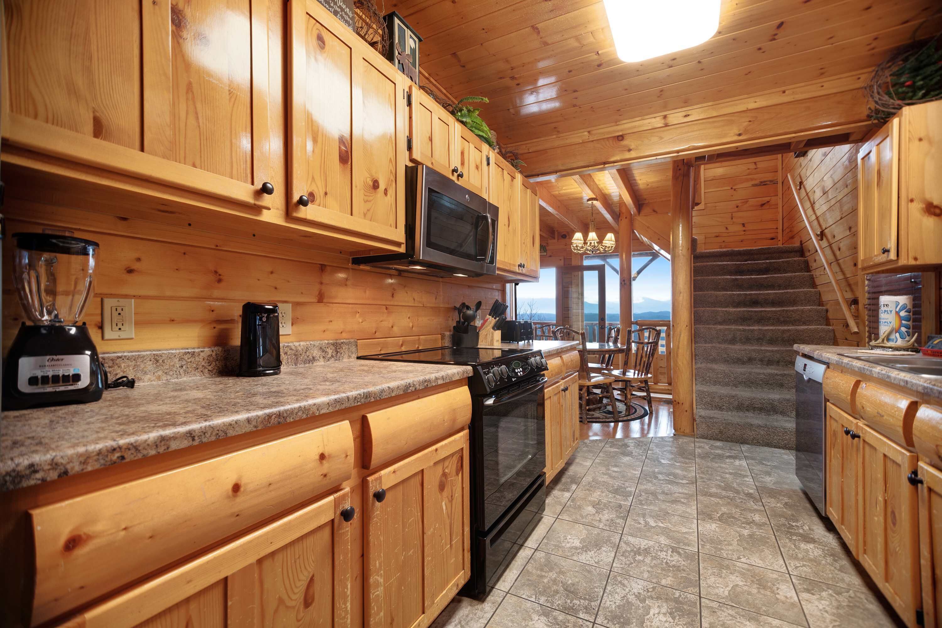 A wooden kitchen with granite countertops, a built-in microwave, and a stove.
