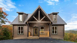 A log cabin with a central entrance, two side porches, and a triangular roof structure. - Luxe Mtn View Cabin, Sleep 8, Hot Tub, Games, Theater (Sevierville)