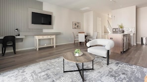 A modern living room with a flat-screen TV, a dining area, and a kitchen. - Landing | Modern 3BD, Gym, Clubhouse (Sapulpa)