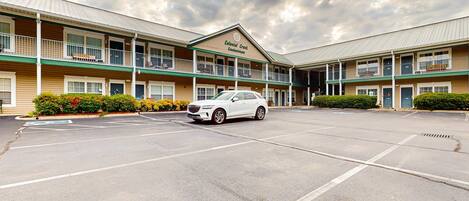 A Colonial Creek Condominium with a parking lot and a white car parked in front.