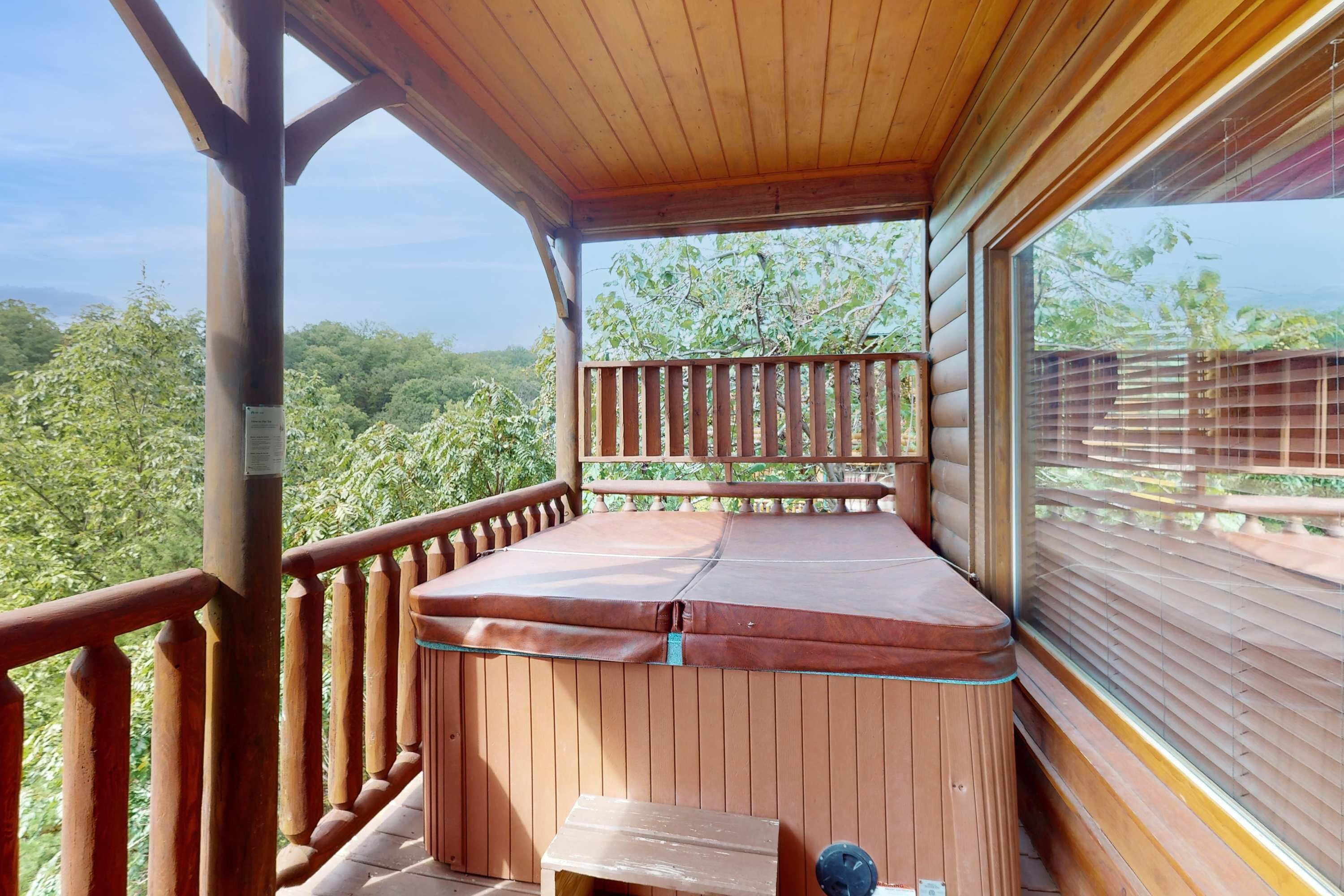 A wooden deck with a hot tub, wooden railings, and a view of the forest.