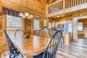 L’intérieur d’une cabane en bois comprend un coin repas, une cuisine et une chambre à coucher située en mezzanine.