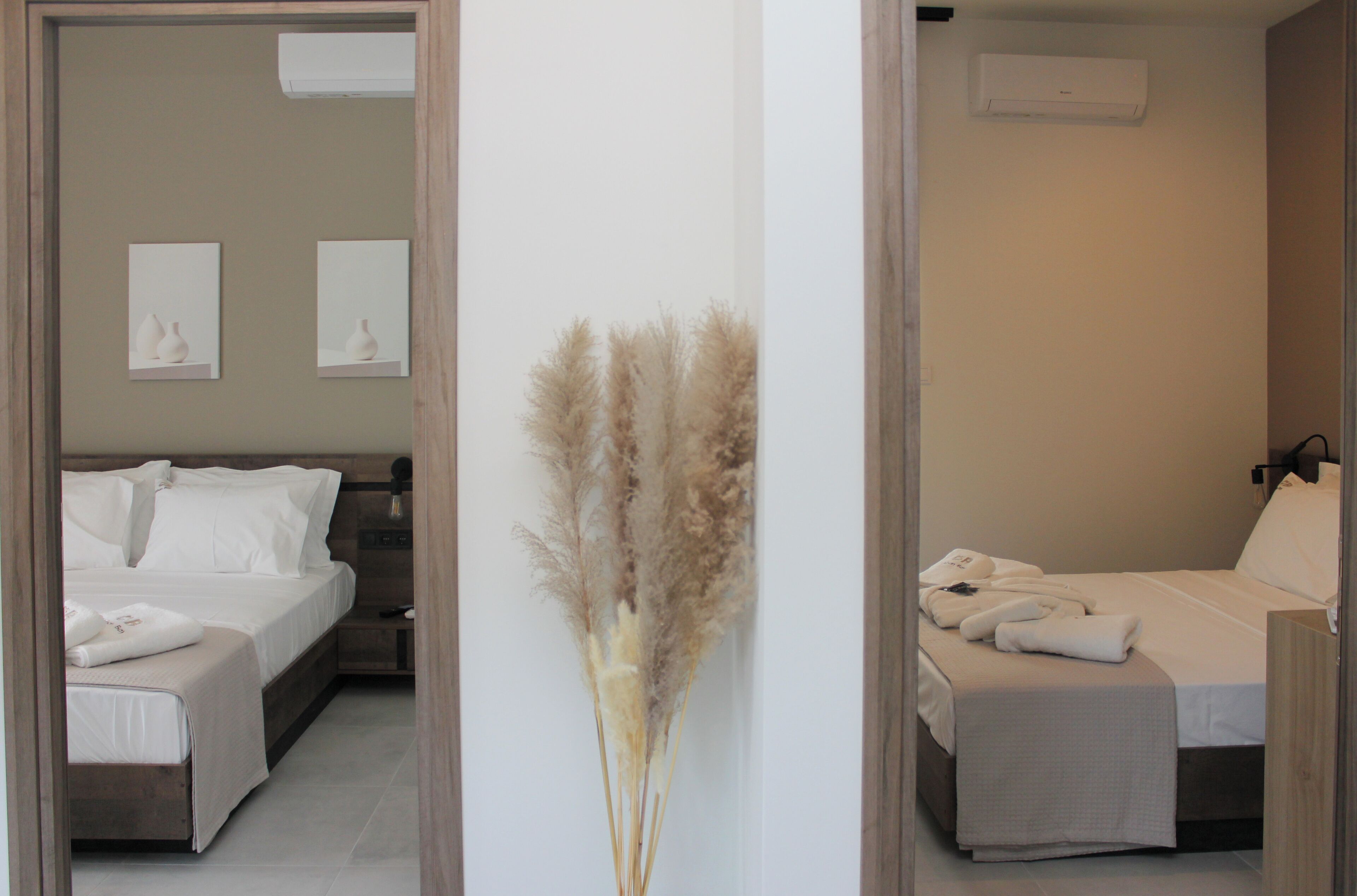 Ein Hotelzimmer mit Bett, Nachttisch und einer Wand-Klimaanlage.
