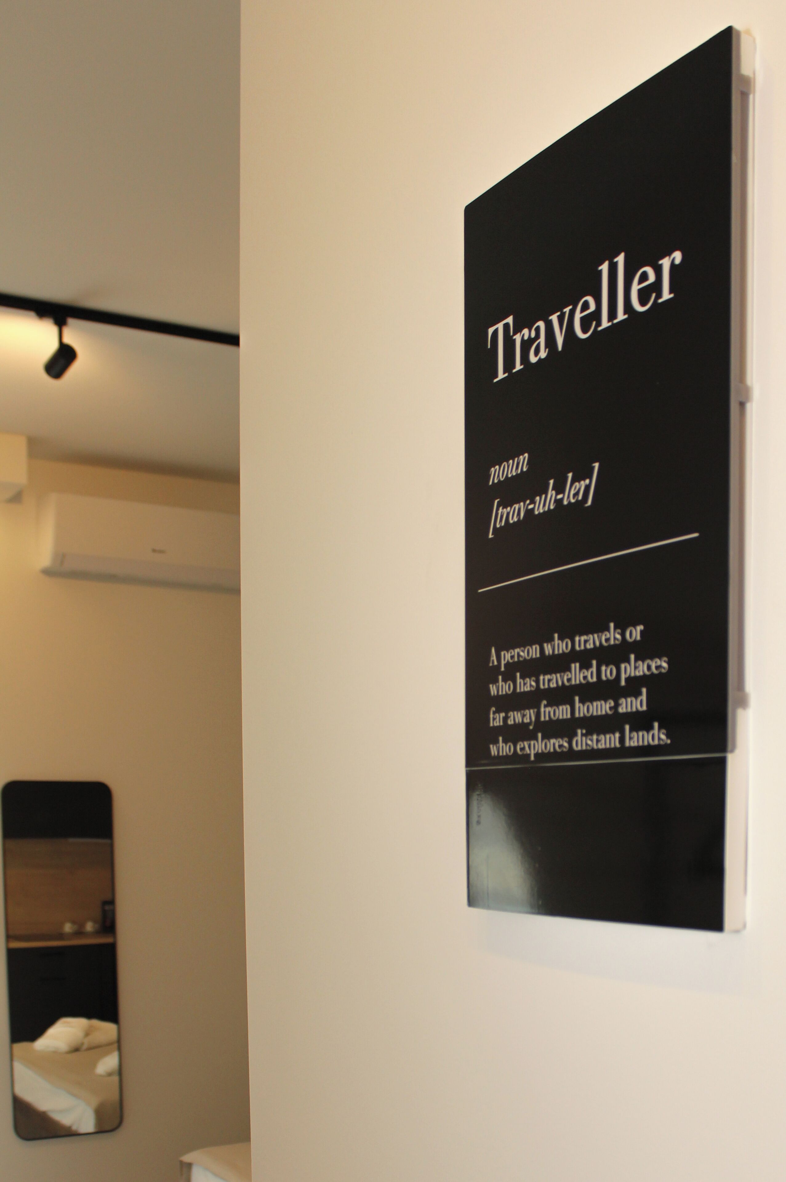 Une plaque fixée au mur, portant le mot « Traveller » et sa définition.