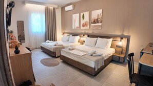 Habitación de hotel con dos camas, un escritorio, una silla y un televisor.