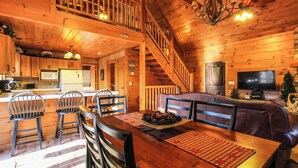 L’intérieur d’une cabane en bois comprend un coin repas, une cuisine et un salon.