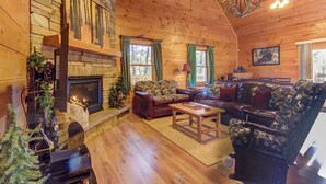 L’intérieur d’un chalet confortable, avec une cheminée, un plancher en bois et un canapé en cuir.