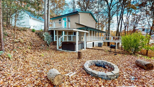 Eine Hütte mit Veranda, Feuerstelle und Terrasse.