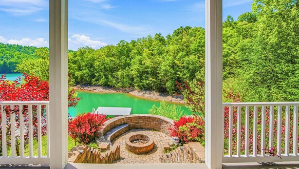 A gazebo with a circular brick design, surrounded by red flowering plants and a view of a green lake. - Lakefront Retreat N Norris Lake・Dock W Slide・Games (LaFollette)