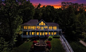 A two-story house with a balcony, surrounded by trees and a well-maintained garden. - Lakefront Retreat N Norris Lake・Dock W Slide・Games (LaFollette)
