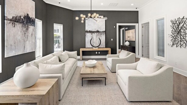 Una sala moderna con un conjunto de sofá, una mesa de centro y un jarrón decorativo.