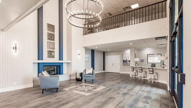 A spacious lobby with a fireplace, seating area, and a dining setup. - Landing | Spectacular Studio, Gym, Yoga Studio (Port Charlotte)