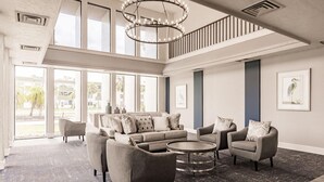 A spacious living area with a large sofa set, a coffee table, and a chandelier. - Landing | Spectacular Studio, Gym, Yoga Studio (Port Charlotte)