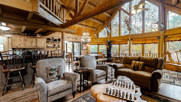 A rustic cabin interior with wooden beams, a dining area, and a cozy seating arrangement. - Upscale Cabin W Hot Tub, Sleeps 22・Game Room・Pool (Sevierville)