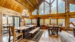 A rustic wooden interior with a large dining table, benches, and a fireplace. - Upscale Cabin W Hot Tub, Sleeps 22・Game Room・Pool (Sevierville)