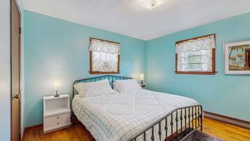 A bedroom with a bed, nightstands, and wall-mounted lamps.