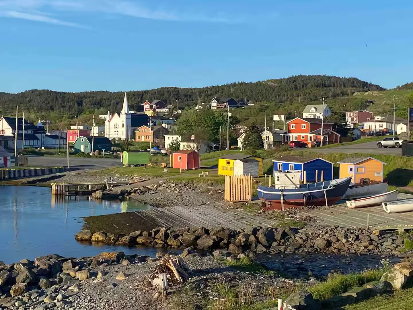 A coastal village with colorful buildings, a dock, and boats.