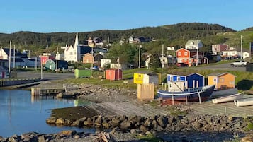 A coastal village with colorful buildings, a dock, and boats.