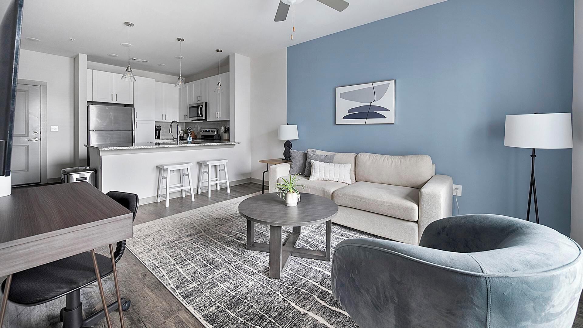 A modern living room with a sofa, a coffee table, and a dining area with a table and chairs.