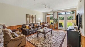 A living room with a fireplace, a sofa, a coffee table, and a television. - Cozy 2BR Resort Condo Near Dollywood・Pools ・Sauna (Pigeon Forge)