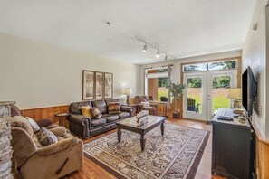 A living room with a fireplace, a sofa, a coffee table, and a television. - Cozy 2BR Resort Condo Near Dollywood・Pools ・Sauna (Pigeon Forge)