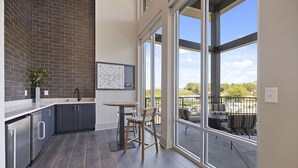 A modern kitchen with dark tiles, a large window, and a view of the outdoors. - Landing | Stylish 1BD, Pool, Clubhouse (Nashville)