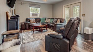 A living room with a sectional sofa, a recliner, a coffee table, and a television mounted on the wall. - Lakefront Cabin, Sleeps 14・2 Level Dock・Sun Deck (LaFollette)