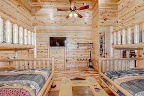 A cabin with two bunk beds, a ceiling fan, a TV, and a small window. - Serene & Spacious Log Cabin・Hot Tub・Screened Porch (Gatlinburg)