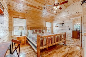 A wooden cabin interior with a bed, a desk, and a chair. - Serene & Spacious Log Cabin・Hot Tub・Screened Porch (Gatlinburg)