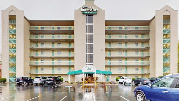 Un hôtel à plusieurs étages, doté d’une entrée principale, de balcons à chaque étage et d’un parking situé à l’avant.