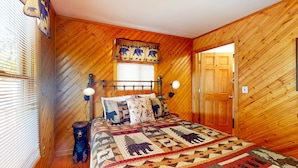 A wooden-paneled bedroom with a bed, a window with blinds, a door, and a wall-mounted lamp. - 1 Mi. from Downtown Gatlinburg・Games・River View (Gatlinburg)