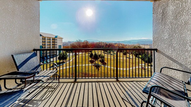 Un balcone con vista su un parco e edifici in lontananza.
