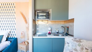A compact kitchen with a built-in oven, a coffee maker, and a sink. - L'Illusioniste studio vue mer dans le Suquet (Cannes)