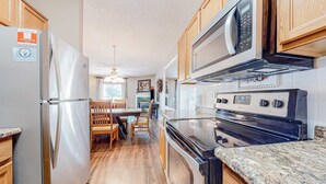 A modern kitchen with stainless steel appliances, wooden cabinets, and a granite countertop. - Mtn View Condo, Sleeps 8, Pool W Lazy River, Hot Tub (Pigeon Forge)
